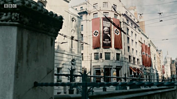 A still from the first episode of SS-GB shows a banner bearing Karl Marx’s image alongside Nazi banners superimposed with a hammer and sickle.